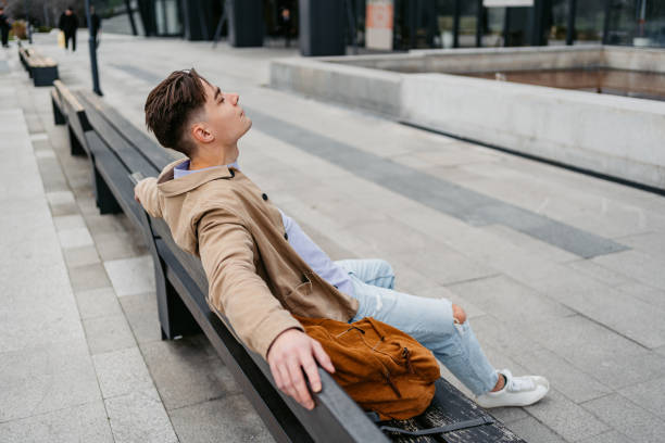 istock Young Man Relaxing On The City Bench 1499957883
