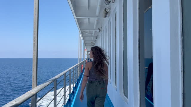 Woman walks along deck of ferry