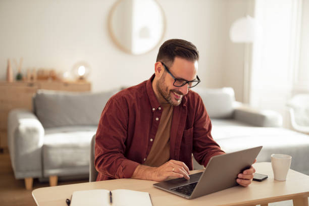 istock Smiling man typing an email, working from home office. 1499958660
