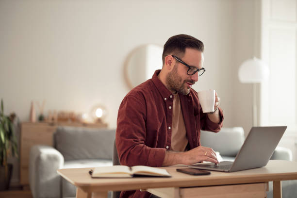 istock Businessman drinking his coffee in the morning while working online. 1499958763