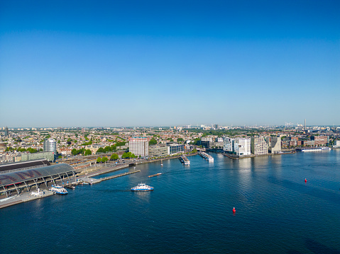 Aerial view of Amsterdam. Drone shot of the river IJ. In the back the skyline of historical Amsterdam.