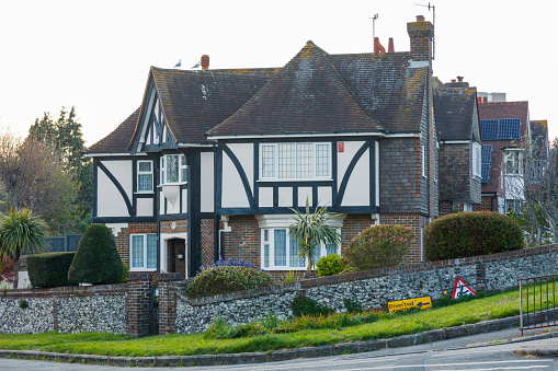 Eastbourne, England - April 30, 2023: Colour image depicting the exterior of a traditional detached English house in the countryside, with a freshly manicured lawn and garden.