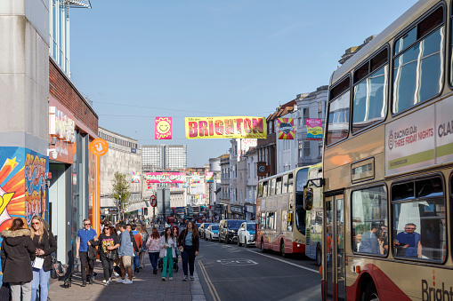 Brighton, United Kingdom - April 29, 2023: Locals and tourists are walking and shopping on the street enjoying the beautiful day and laid-back lifestyle in Brighton.