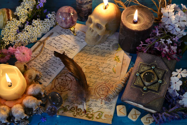 istock Candles, runes and manuscript with spell on witch ritual table. Occult, esoteric and fortune telling still life. Mystic background with vintage objects 1499961578