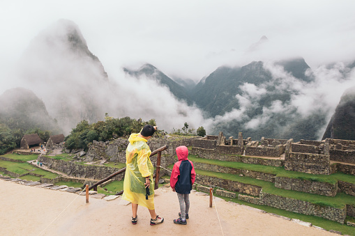 Peruvian mother showing her daughter the ruins of Machu Picchu