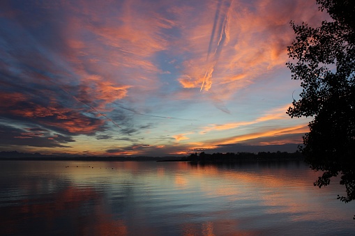 A beautiful sunset over a tranquil lake, creating a peaceful and calming atmosphere