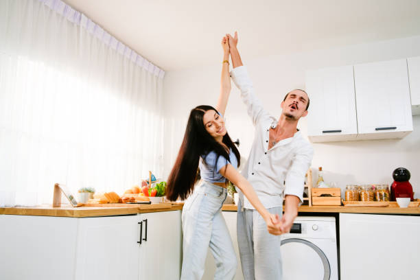 istock Happy cheerful Caucasian couple dancing together in the kitchen, spending time together. Energetic and fun relationship dance with romantic moments of happiness while preparing a meal in the kitchen. 1499966607