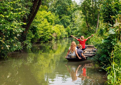 Marsh-Happy family in vacation in marais poitevin- boat, canal and green vegetation- France
