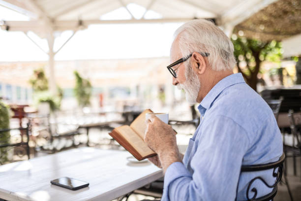 istock Senior man reading book and smiling 1499970936