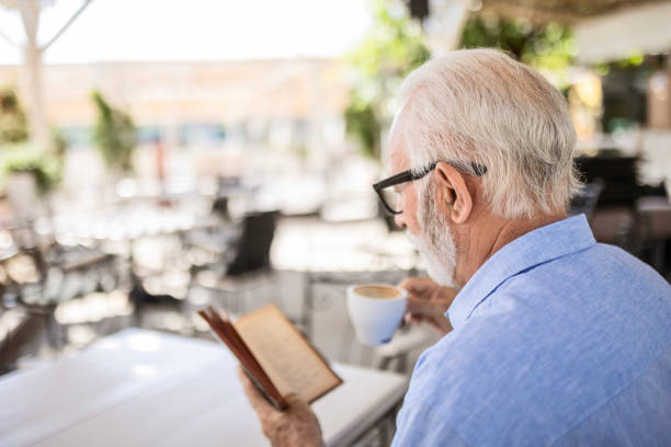 istock Senior man reading book and smiling 1499970947