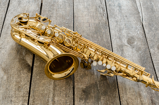 Beautiful golden saxophone on wooden background