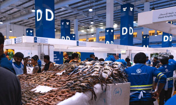 Dubai, Deira, United Arab Emirates - April 2023: Waterfront fish market. Retailers offer fresh fish and crustaceans at their stalls in the market. Different kinds of fish on ice. Cod, Hamour fish, sea bream, Shari fish, kingfish, prawn and shrimps.