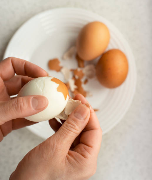 istock Caucasian female peeling hard boiled eggs closeup view from above 1499982791