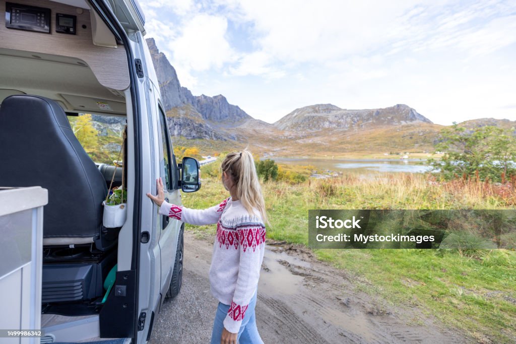 Viaje por carretera: mujer saliendo de una autocaravana - Foto de stock de 30-34 años libre de derechos Viaje por carretera: mujer saliendo de una autocaravana - Foto de stock de 30-34 años libre de derechos