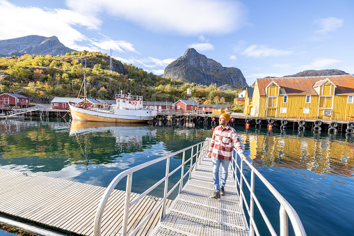 He looks around the beautiful scenery on a sunny day.\nLofoten islands, Norway