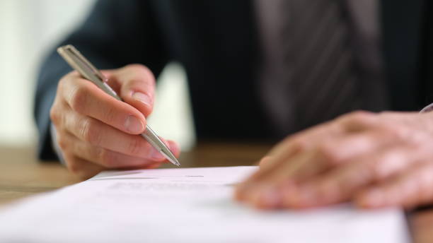 istock Businessman signing document contract with ballpoint pen in office closeup 1499988310