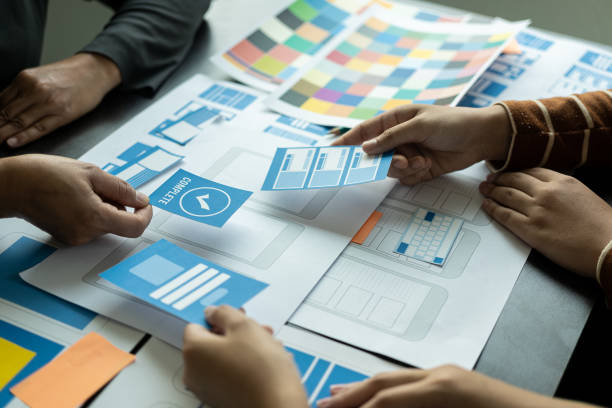 istock UI/UX web design teams are working together to develop mobile application websites too. 
Website development concept with UX UI display system on the front of smartphone 1499988937