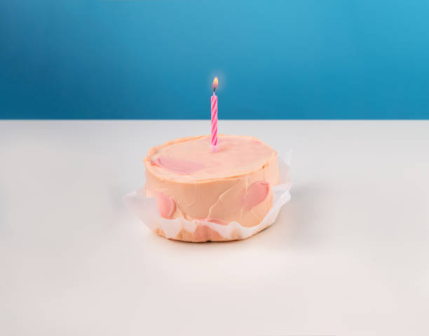 istock pink Bento cake with a candle on a bright background with copy space. 1499989444