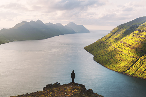 Tourist on famous viewpoint on Klakkur peak near Klaksvik city on Kalsoy island, Faroe Islands, Denmark. Landscape photography