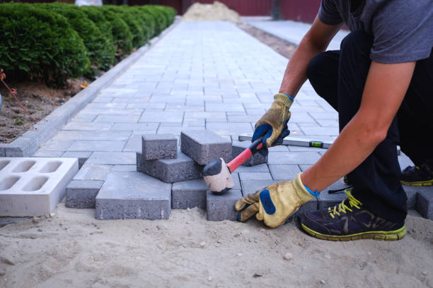 The master in yellow gloves lays paving stones stock photo