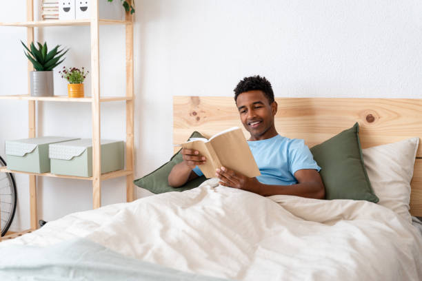 istock Man enjoying a book in bed on sunday. 1499996052