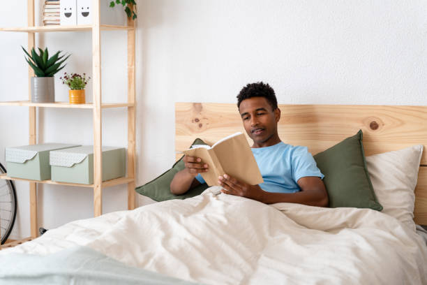 istock Man enjoying a book in bed on sunday. 1499996138