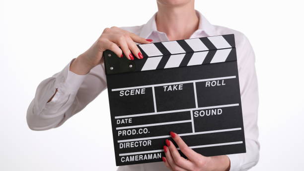 istock Woman assistant director banging clapper while filming closeup 1499996231