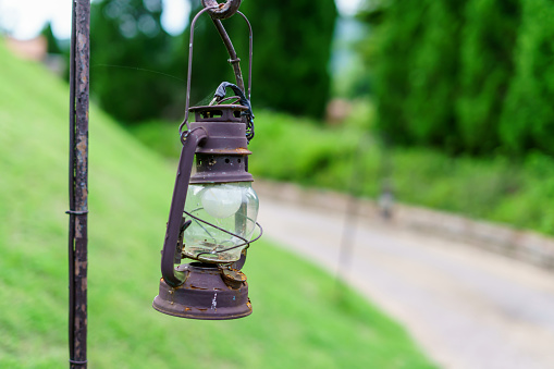 Vintage lamp on footpath with green meadow field