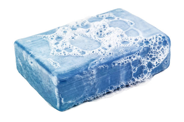 Piece of blue soap with sud foam isolated on white background
