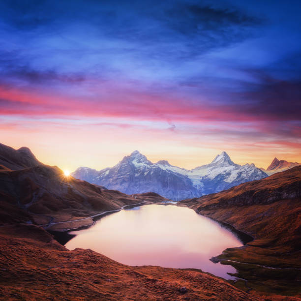 vistas en el lago bachalpsee en montañas de los alpes suizos - grindelwald european alps blue sky fotografías e imágenes de stock