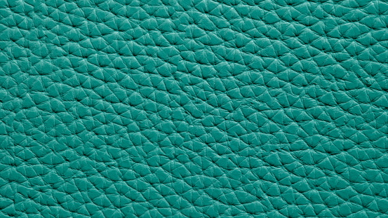 Green corrugated genuine leather background closeup macro. Leather material texture concept