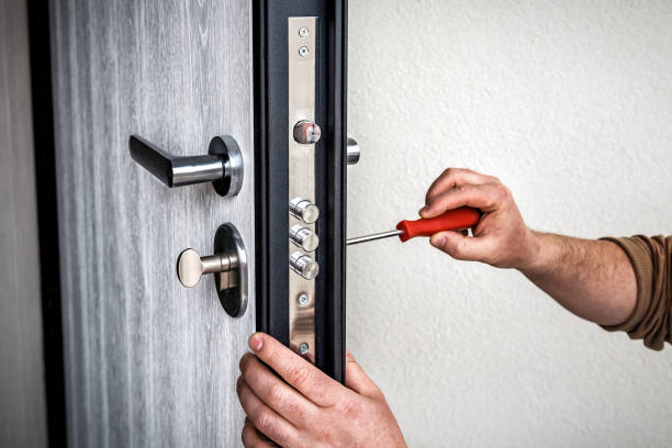 Handyman repair the door lock in metal entrance door, Man fixing lock with screwdriver stock photo