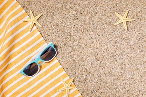 istock Sunglasses on a beach mat in the sand 1500014082