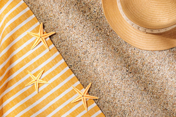 istock Straw hat and beach towel on the beach sand 1500014113
