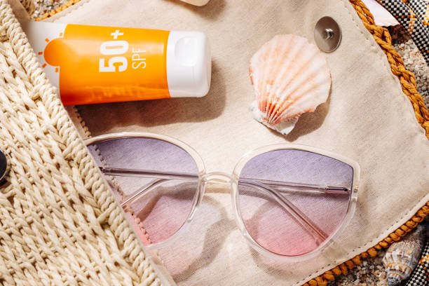 istock Sunscreen and sunglasses in a woven straw bag on a sandy beach 1500014381