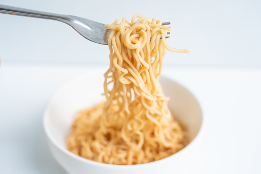 Boiled instant noodles on white background. Fast food.