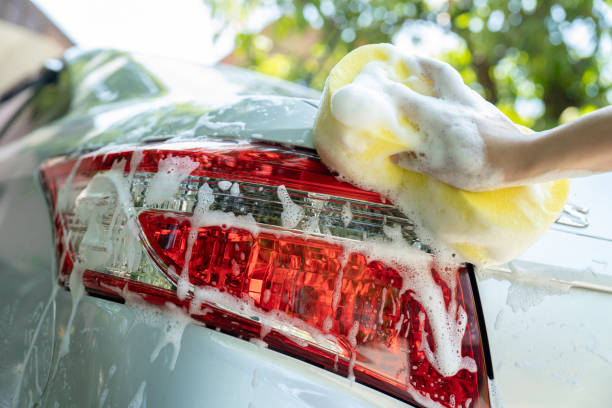 istock female hand with yellow sponge washing car 1500021911
