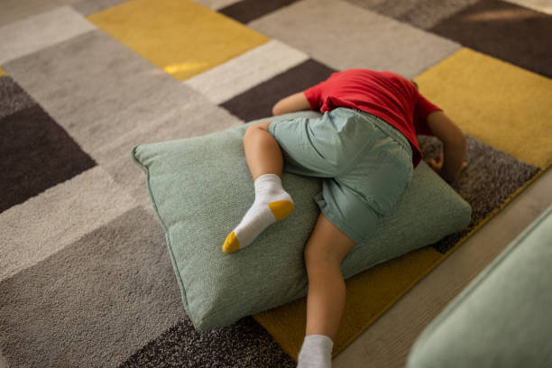 Cute little boy lying on a pillow on the floor at home.