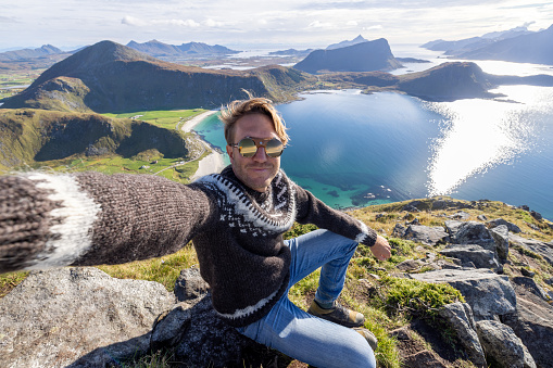 Young man hiking in a beautiful scenery in Norway.\nLofoten islands, Norway