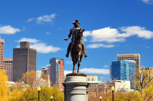 Boston, Massachusetts, USA - October 29, 2022: Equestrian statue of George Washington in the Boston Public Garden. Bronze statue (c 1864) on granite base, sculpted by Thomas Ball. Downtown buildings in the background.