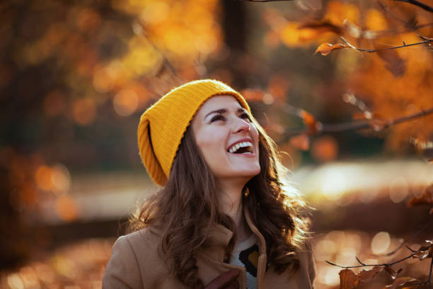 istock smiling elegant female in beige coat and orange hat 1500024609