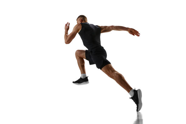 Dynamic image of young man with muscular, strong, fit body, professional runner in motion, training against white studio background Dynamic image of young man with muscular, strong, fit body, professional runner in motion, training against white studio background. Concept of sport, competition, health, strength and speed, ad carpet runner stock pictures, royalty-free photos & images
