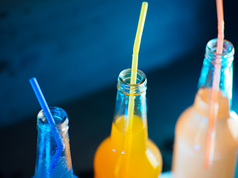 closeup of soda bottles with straws