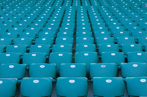 A row of seating chair in sport track, close-up and selective focus. Sport object/background pattern photo.
