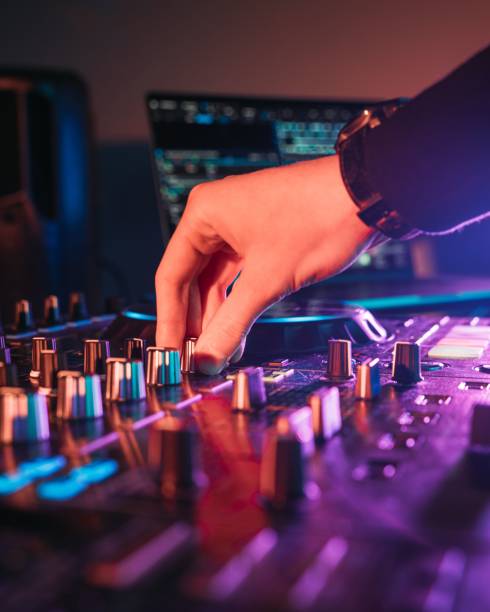 Professional audio mixing board connected to a laptop, displaying the various knobs and buttons.