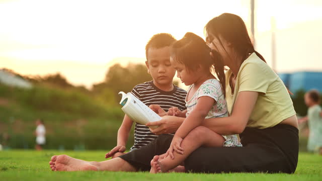 Family reading book at public park