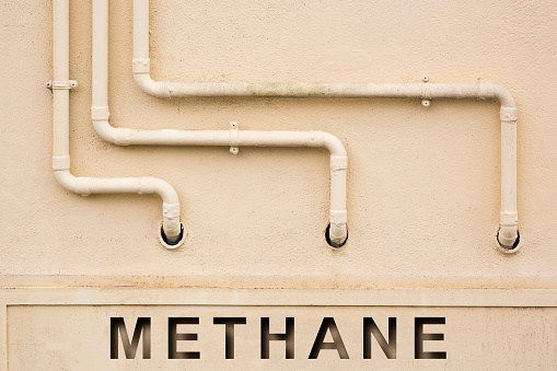 Protective metal box of methane or propane gas against a wall with painted copper pipeline