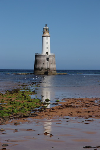 White lighthouse at low tide