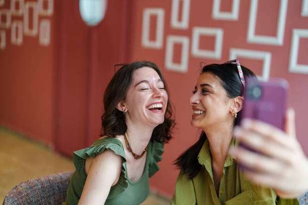 istock Young female adults taking selfies in a cafe. 1500039221