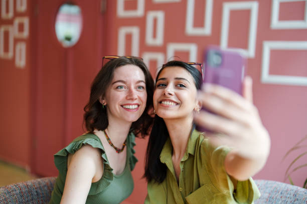 istock Young female adults taking selfies in a cafe. 1500039245